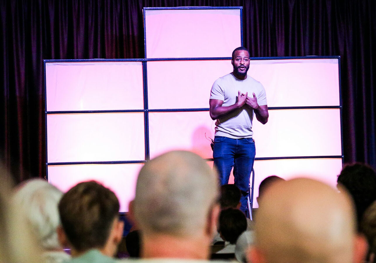 Men speaking in front of an audience